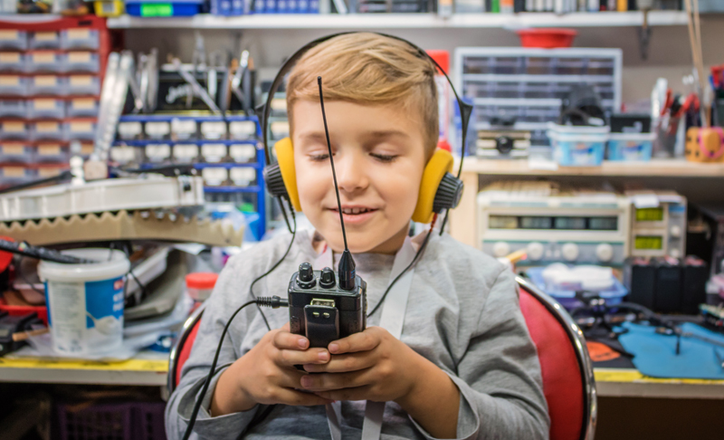 Happy boy with headphones using walkie talkie.